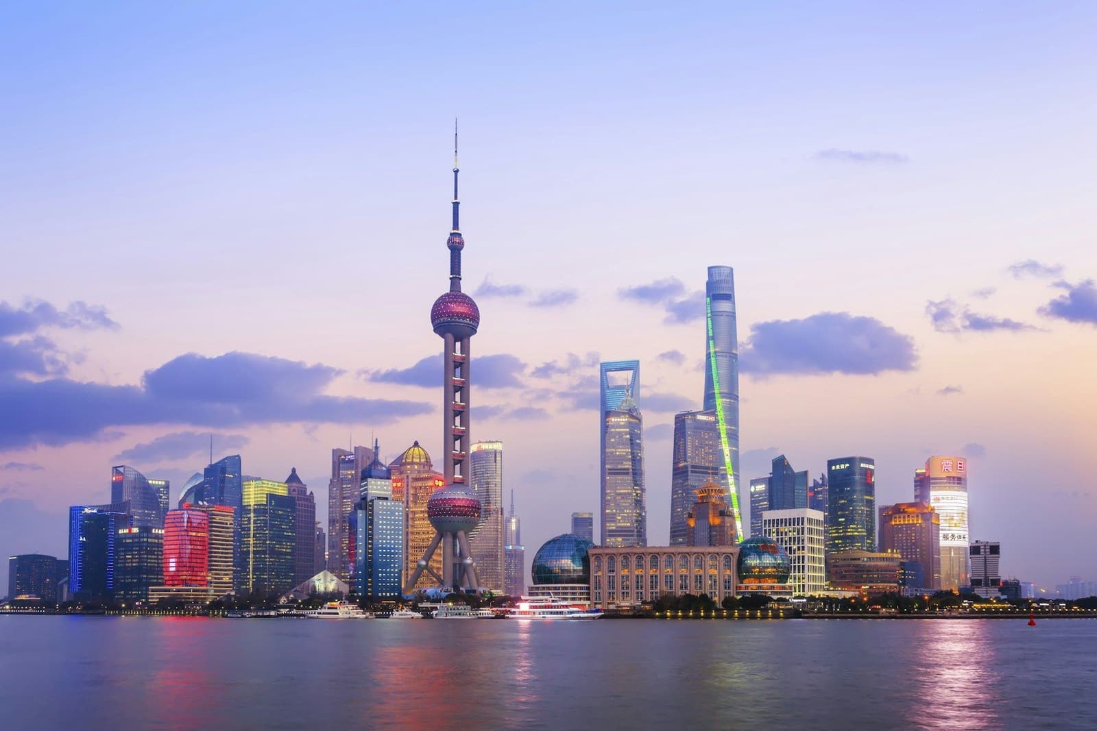 The Shanghai skyline and Oriental Pearl Tower reflected in the Huangpu River at dusk