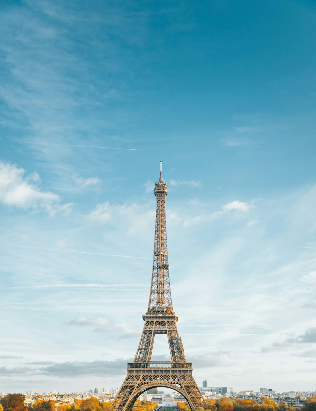 The Eiffel Tower in autumn above the trees of Paris