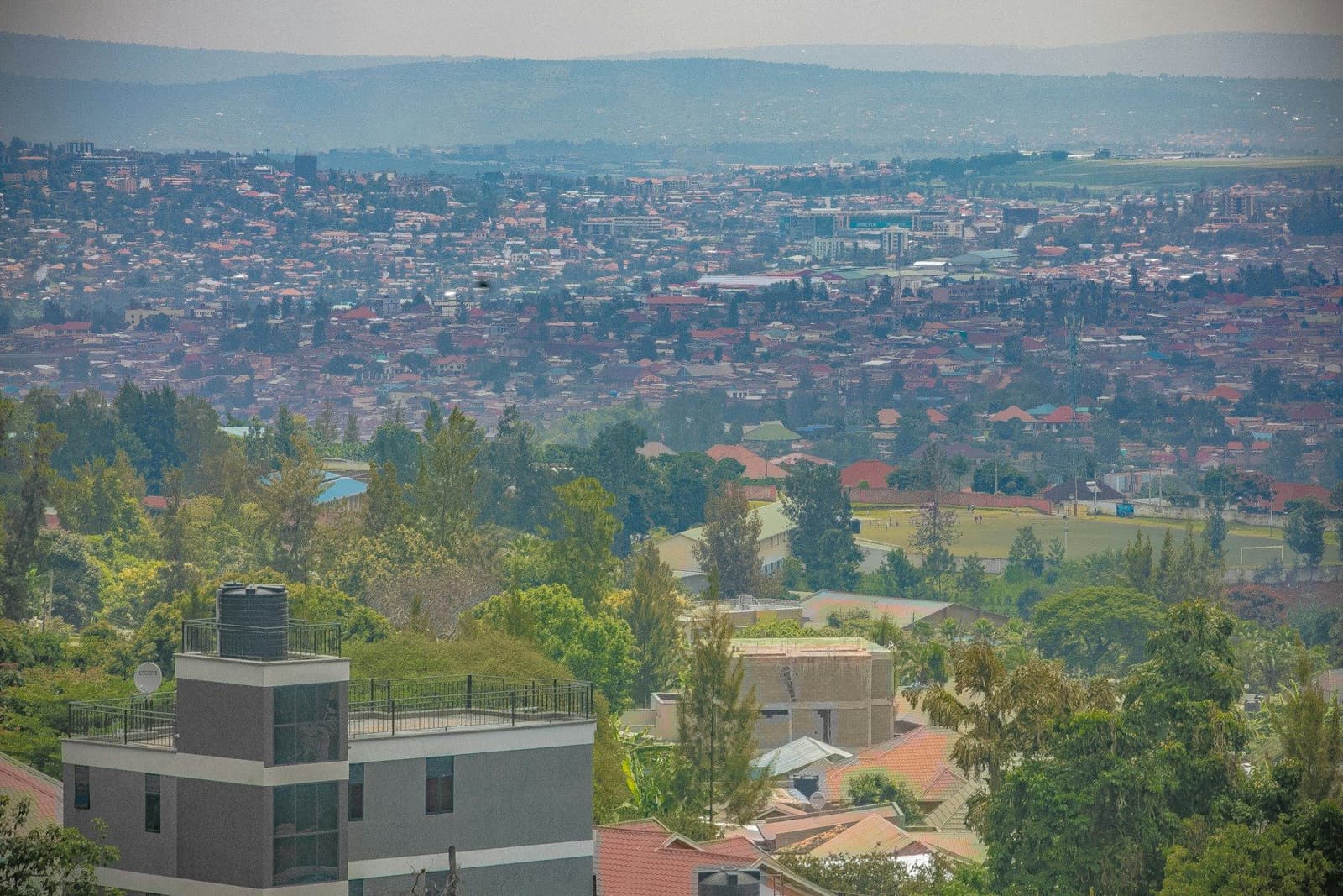 Green hills and red-roofed neighbourhoods of Kigali stretching to the horizon